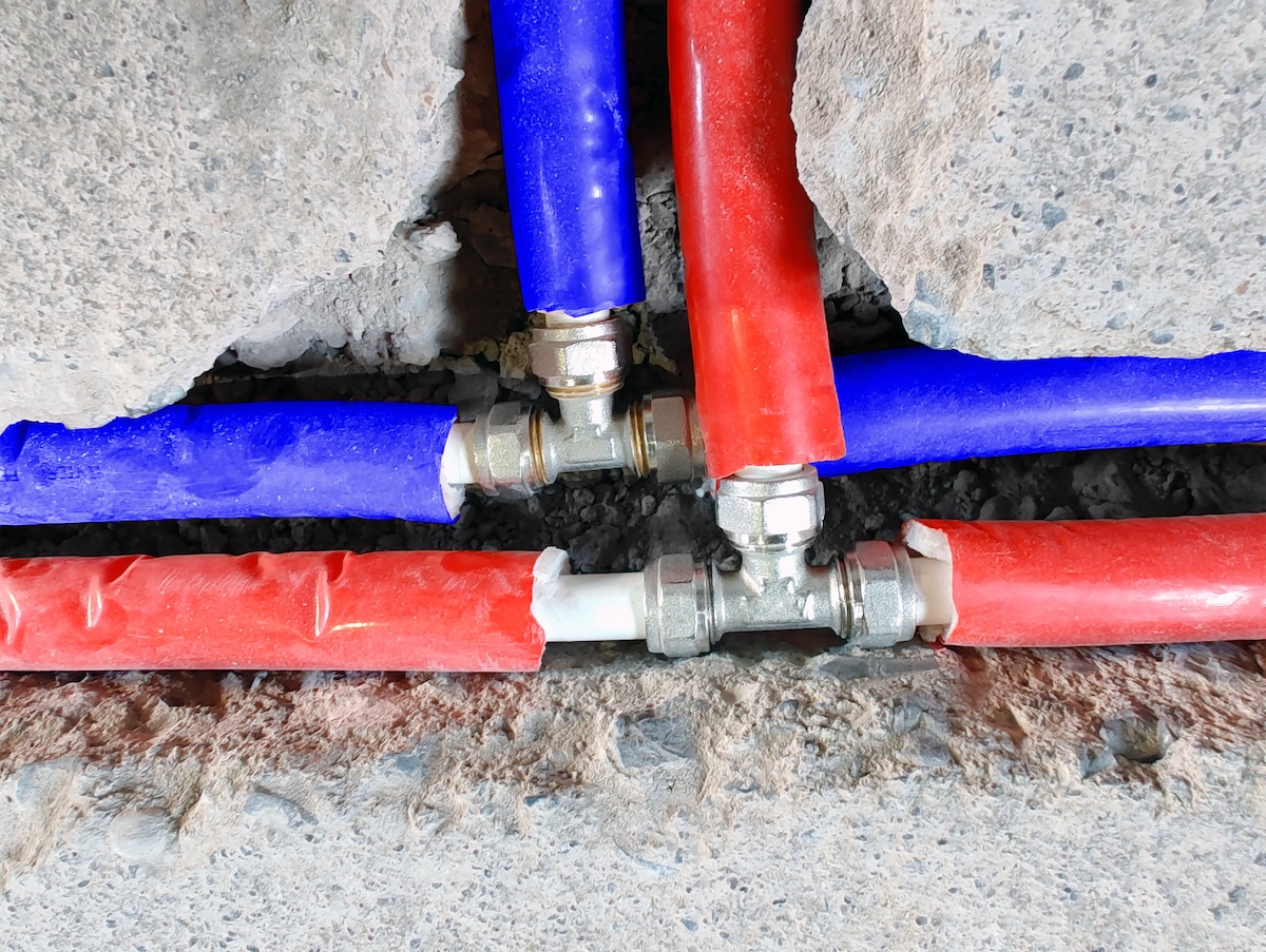 Two sets of red and blue PEX pipes converge.