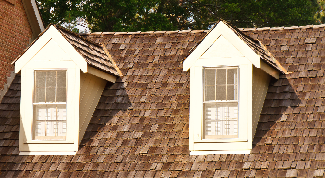 Two windows in dormers on a wood shingle roof