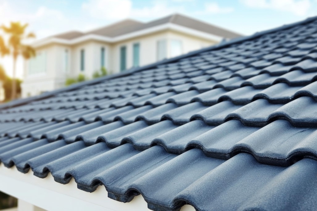 Concrete shingles on roof with sunny sky in the background.