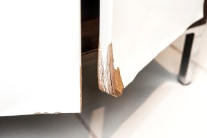 Water damaged high gloss white MDF bathroom vanity cabinet door with molding.
