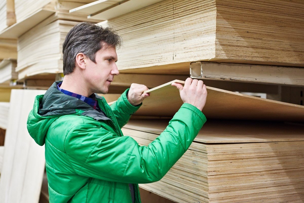 A man is testing the strength of plywood.
