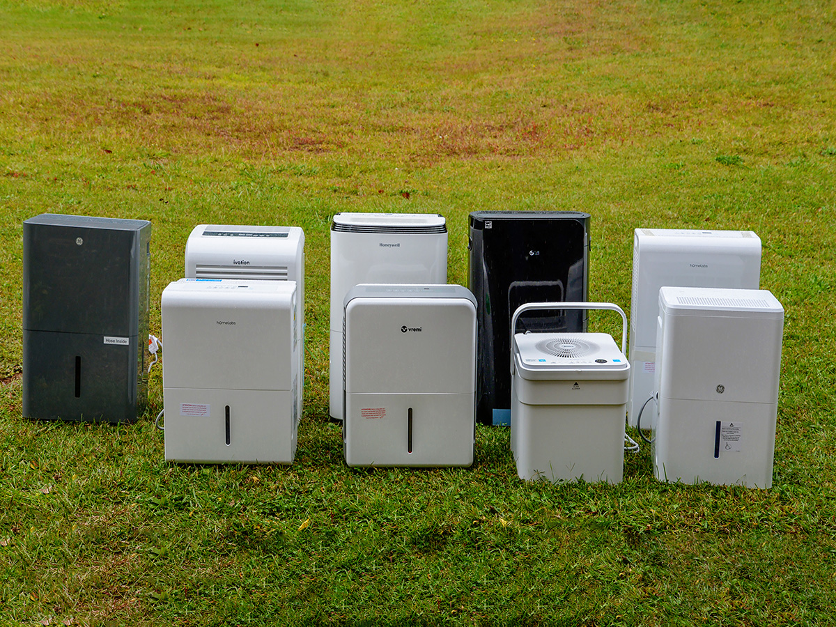 A group of the Best Dehumidifiers for Basements placed together on a green and brown lawn.