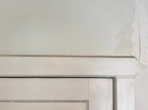 A hairline crack above an interior door frame.