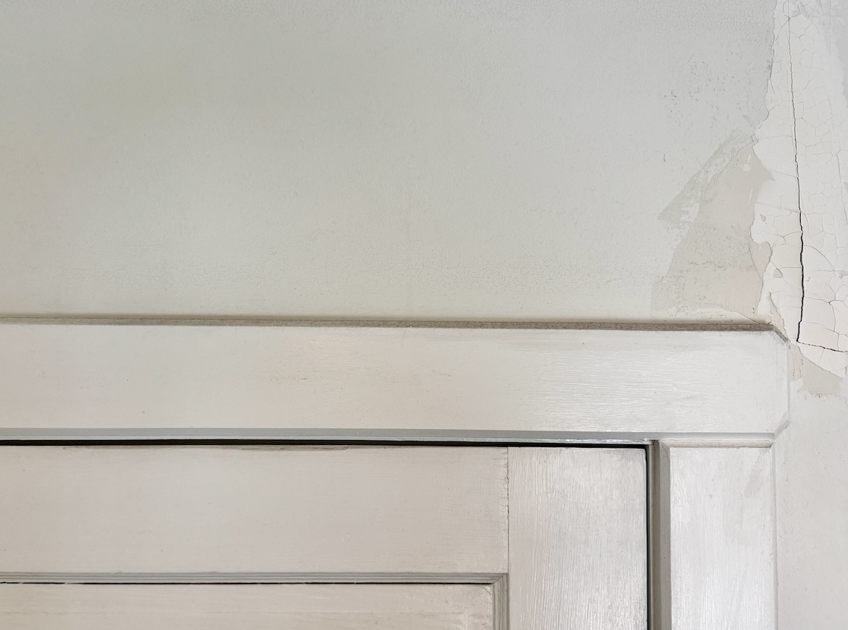 A hairline crack above an interior door frame. 