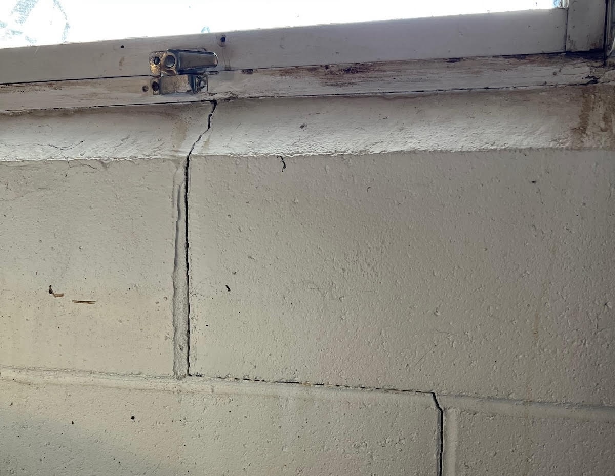 A stair step crack in an interior brick wall.