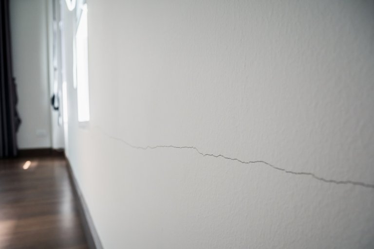 A crack running through a white interior wall.