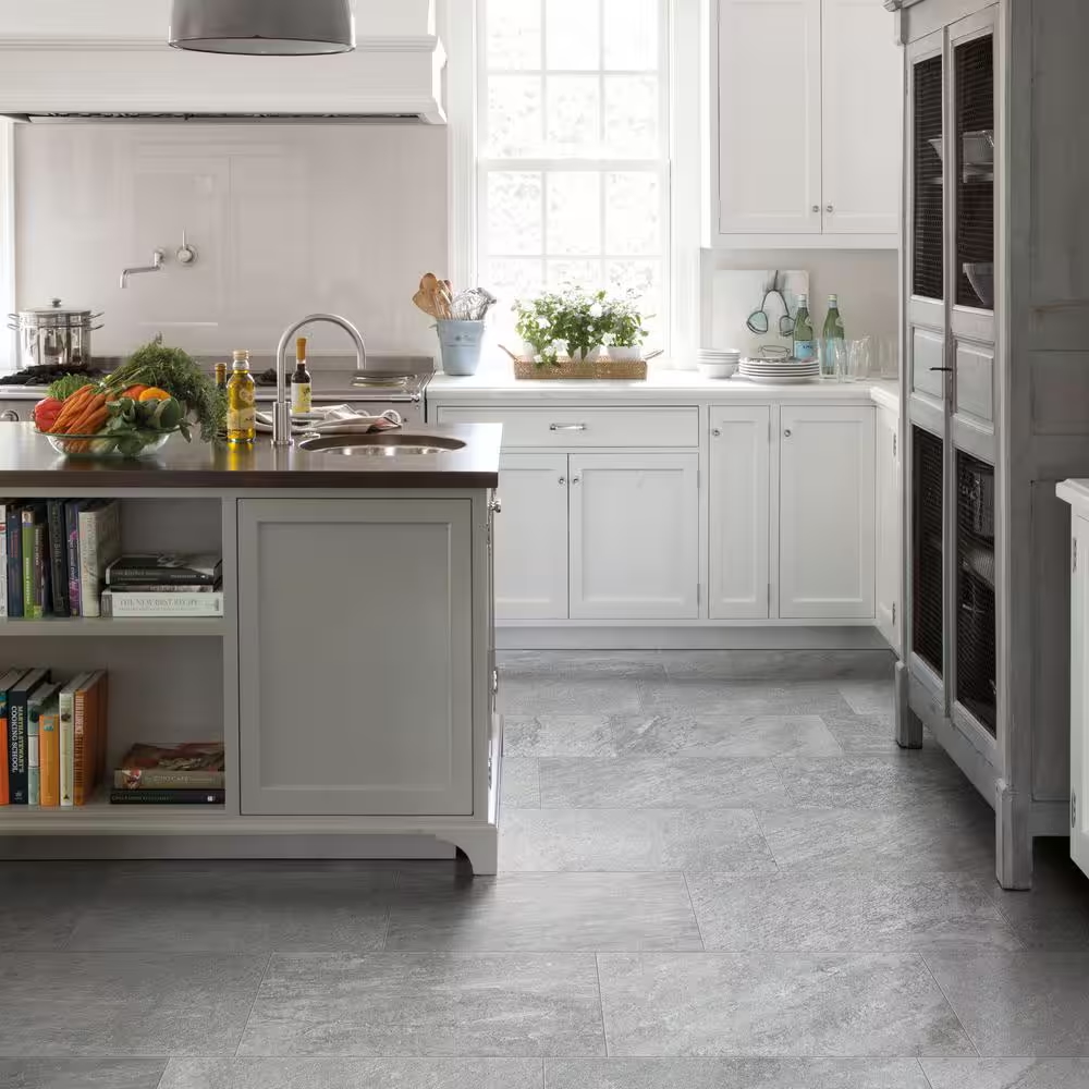 Contemporary kitchen with white tile walls and cabinets on the back wall, and light grey cabinets and island, and light grey tile, in foreground.