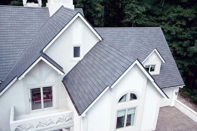 Overhead view of roof of large house with grey metal roofing that looks like slate.