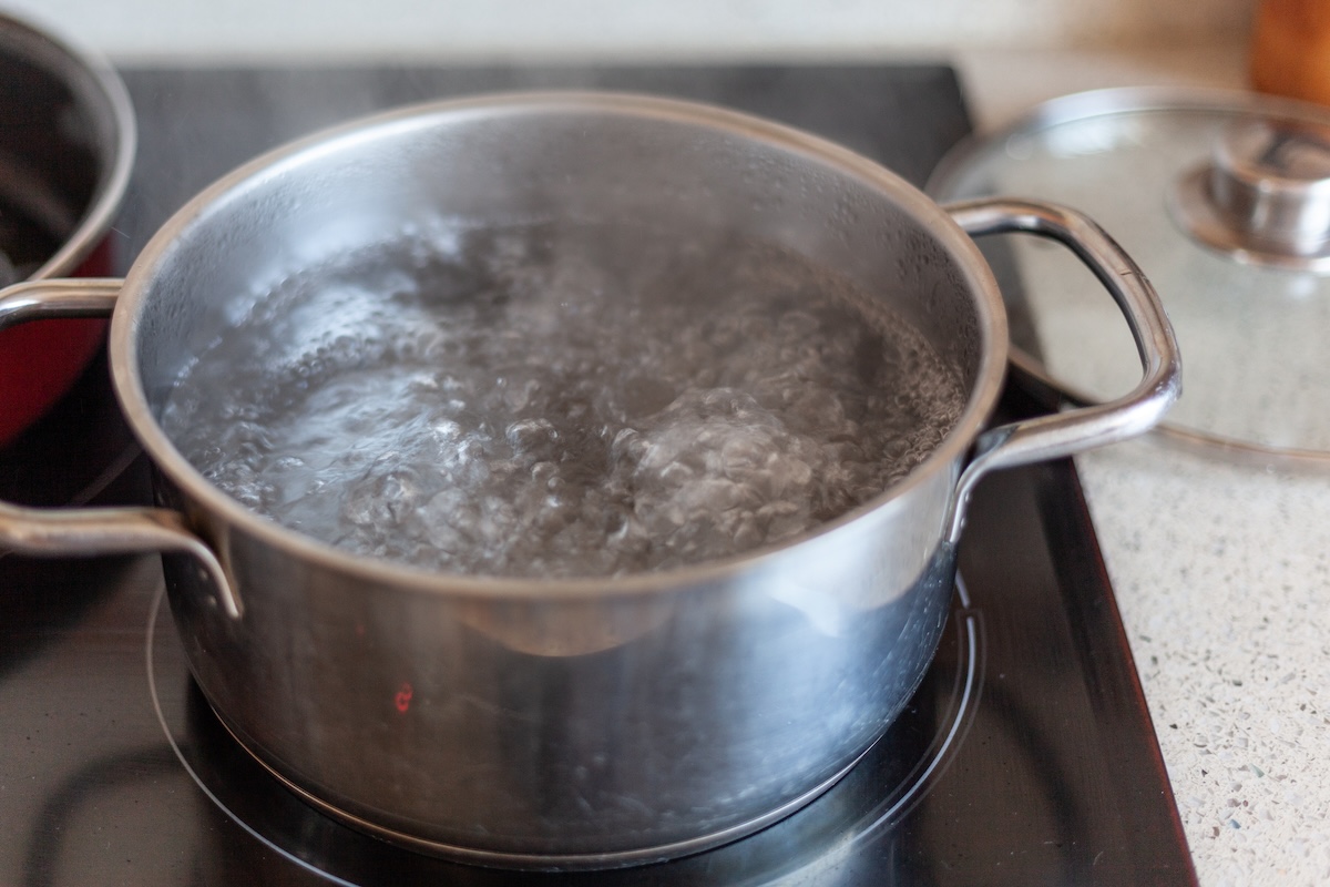 Boiling water on the stovetop in a pot.
