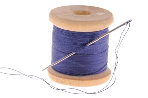 A spool of blue thread on a white background.