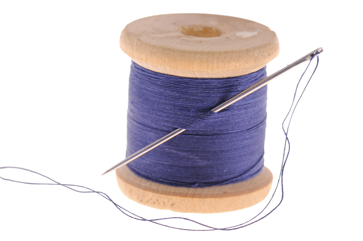 A spool of blue thread on a white background.