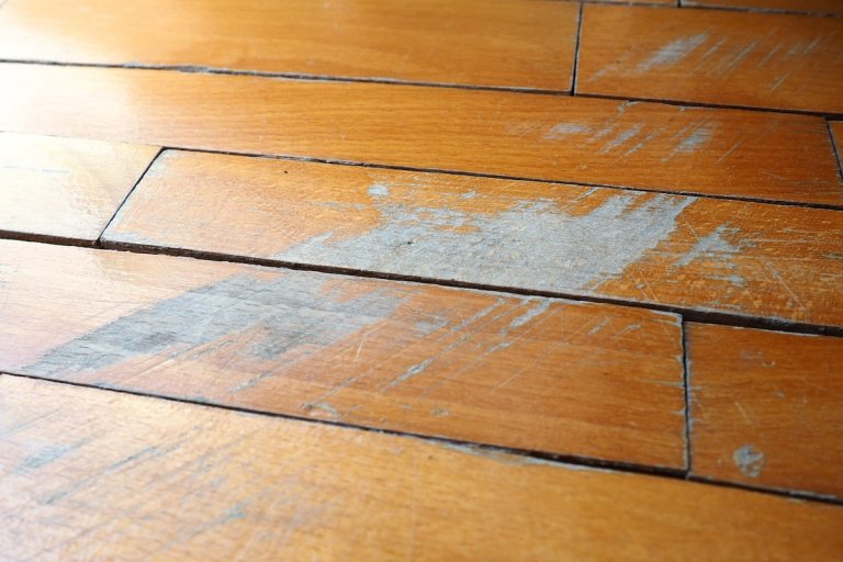 Older hardwood flooring with scratches and signs of wear.