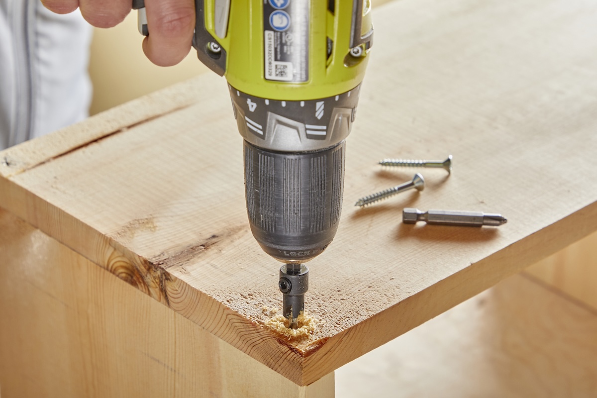 A closeup of a drill making a pilot hole in wood.