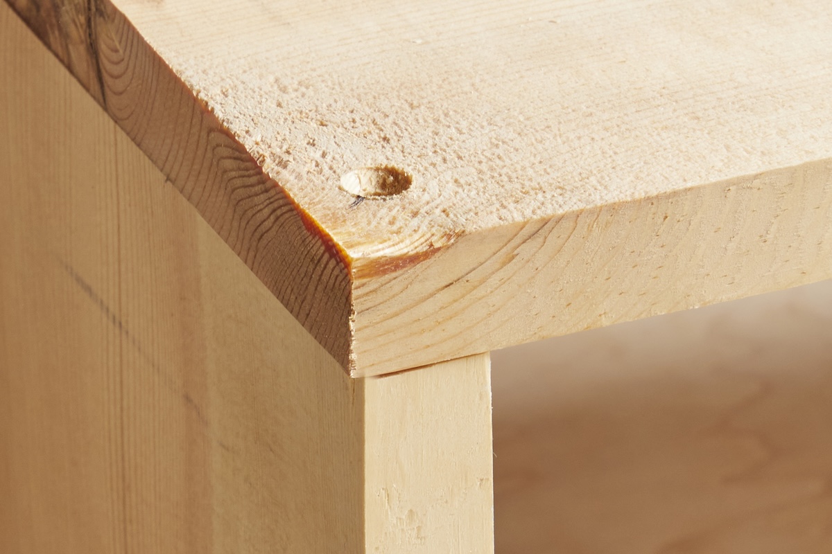 A pilot hole in the corner of the joint of two pieces of wood.