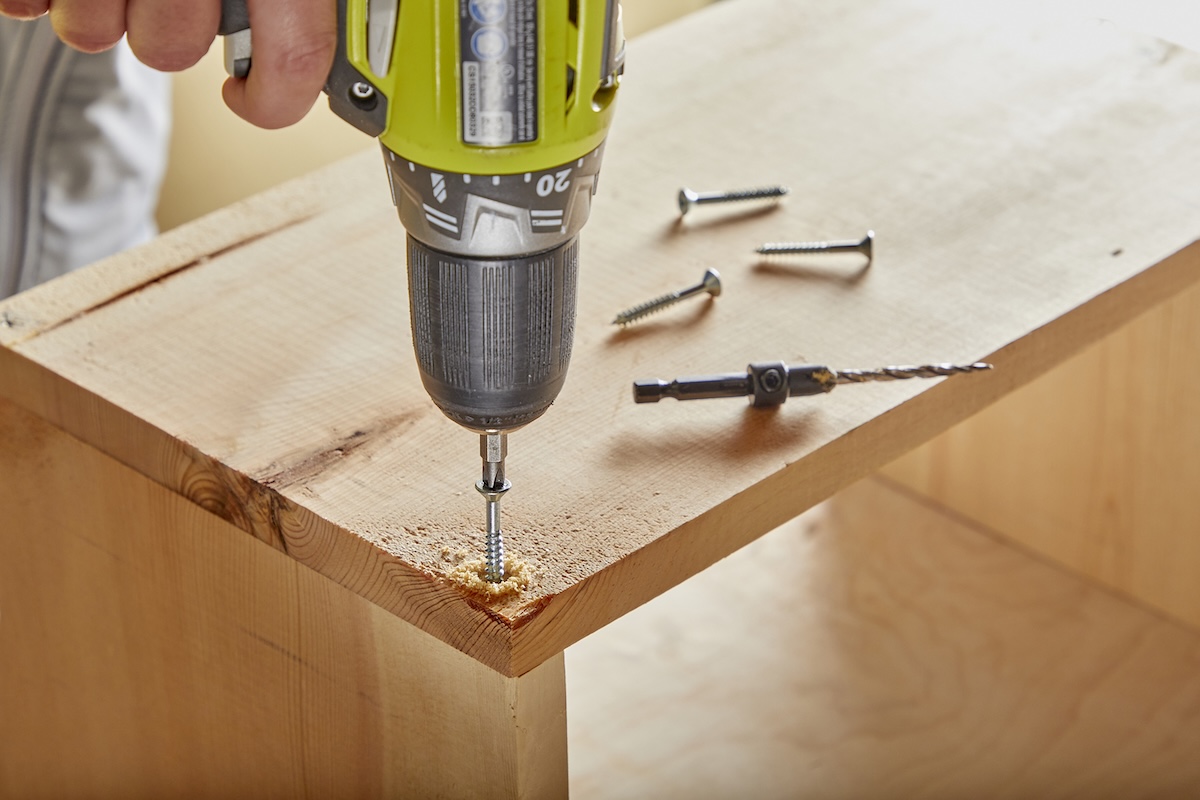 Drill the screw into the piece of wood.