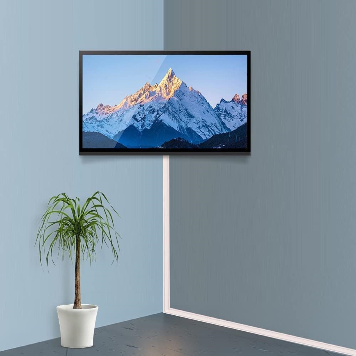 A cord rail hiding a cable leading to a tv on a two-toned blue wall.