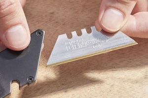Person inserts a Lenox utility knife blade into a utility knife.