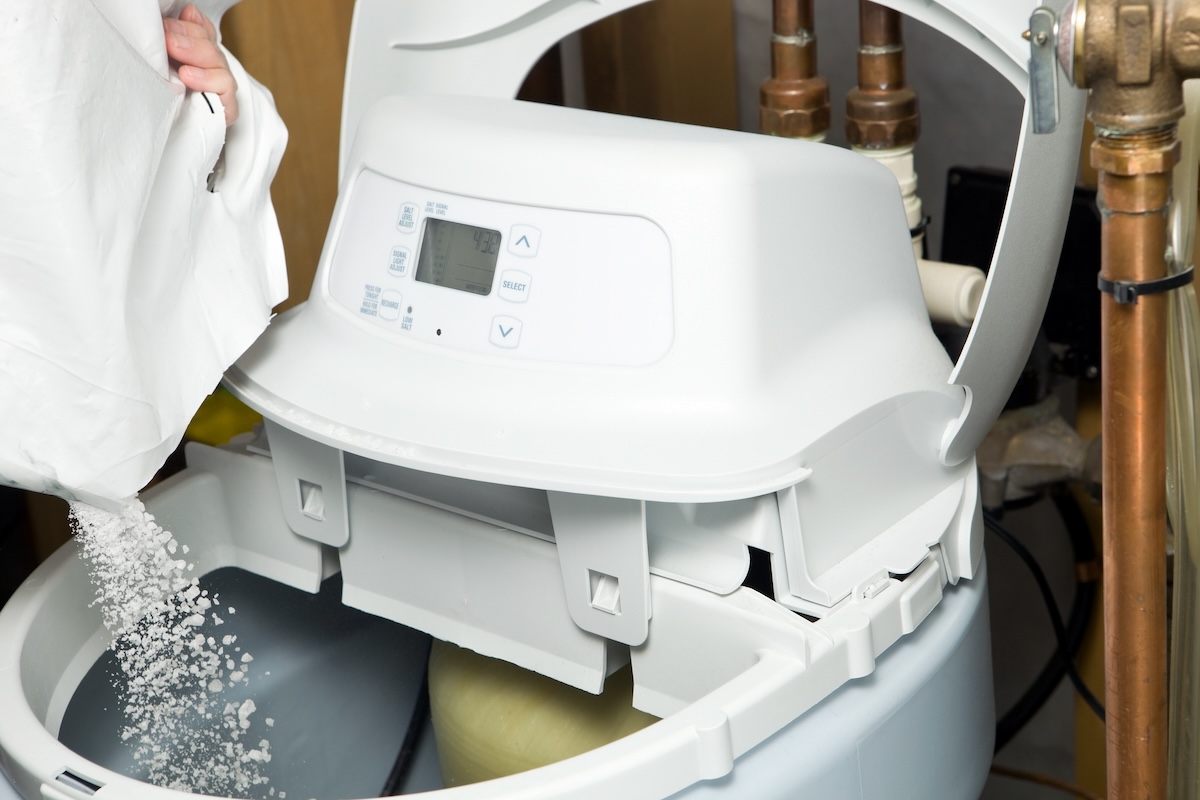 Pouring softener salt into a soft water tank.