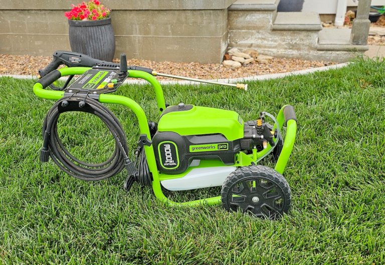 Green pressure washer sitting on a lawn.