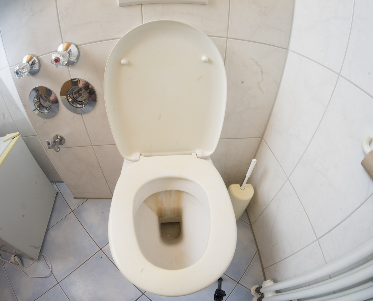 Rust stains the bowl of a white toilet.