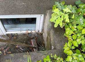 Large pool of water outside of basement window.