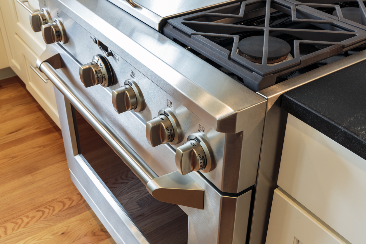 Close up of stainless steel gas range with black iron grates