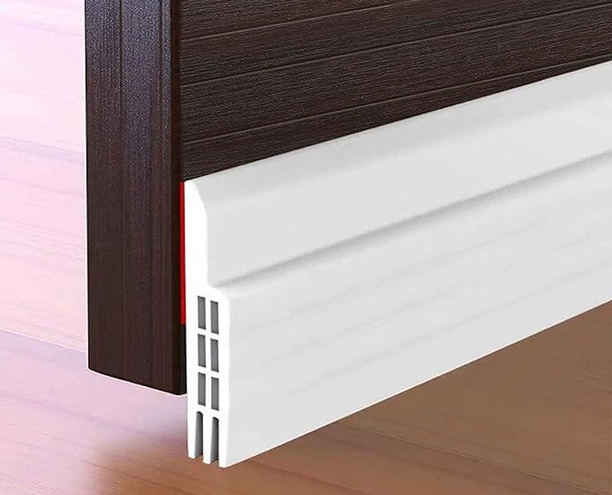 White door sweep on a wooden door.