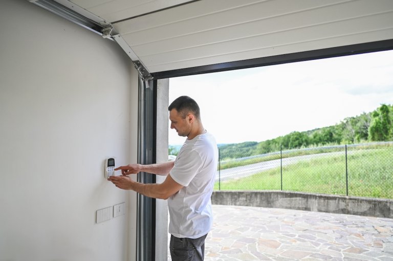A man uses a security pad to close his garage door.