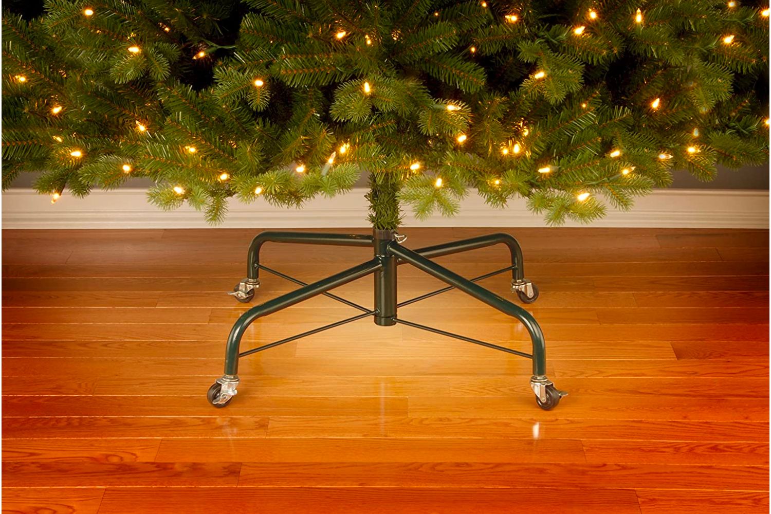 The Best Christmas Tree Stand Option supporting a Christmas tree that has gold lights.