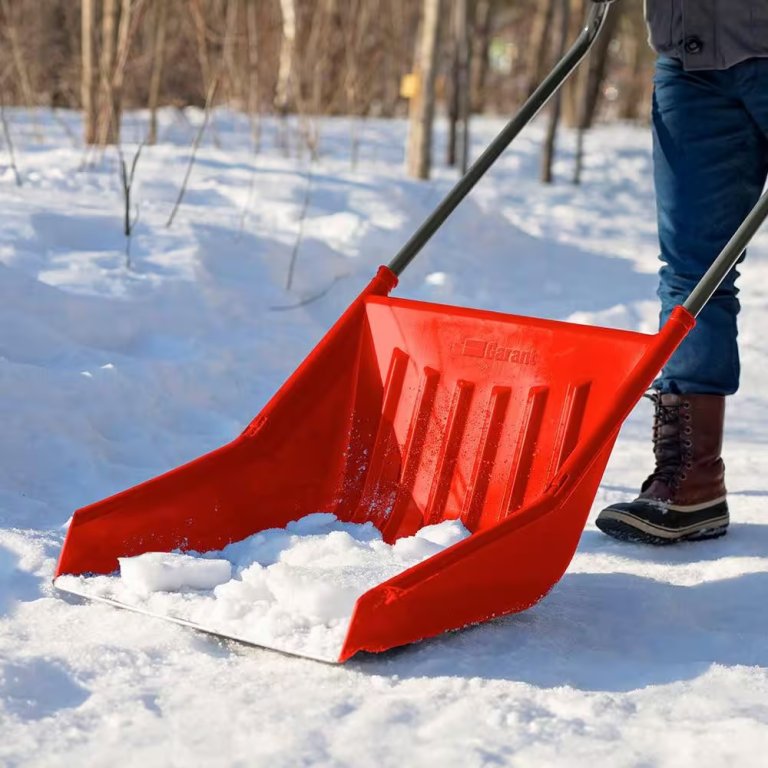 Person using the Garant Sleigh Shovel in the snow.