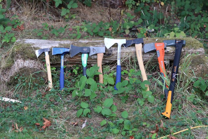 A group of the best axe options together on a horizontal log in the woods