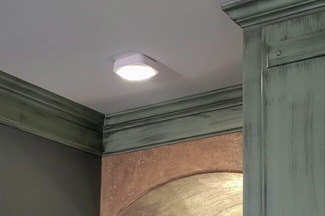 A motion sensor light installed in an indoor hallway.