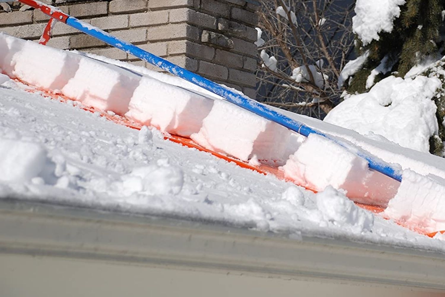 The best roof rake in action breaking a large block of roof snow into smaller segments for removal.