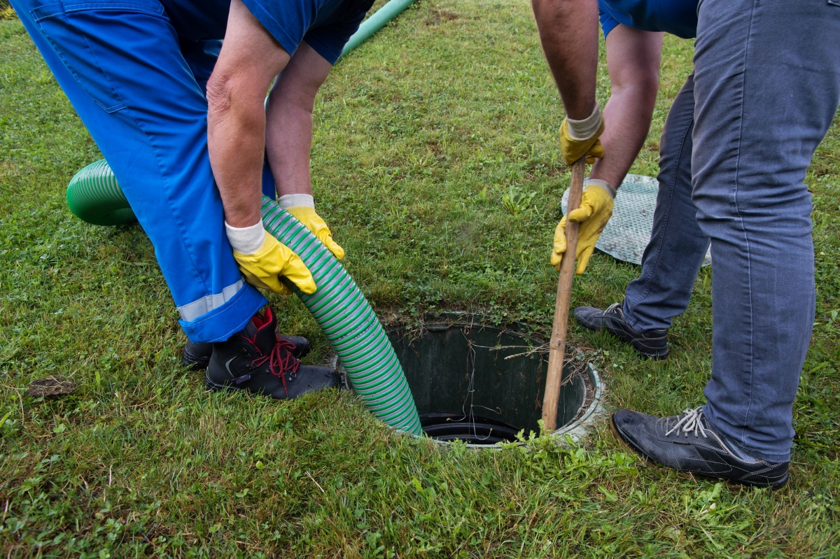 Two people pumping septic system