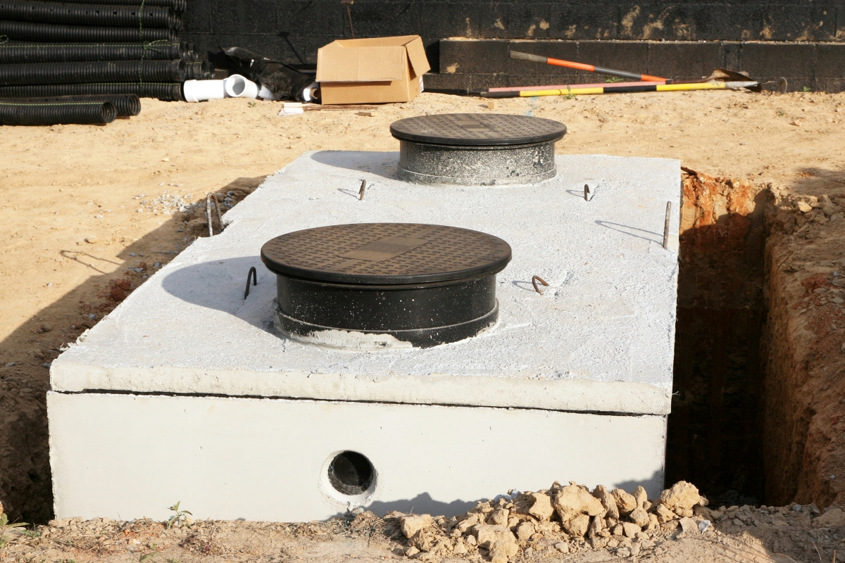 A new concrete septic tank has recently been installed in the ground.