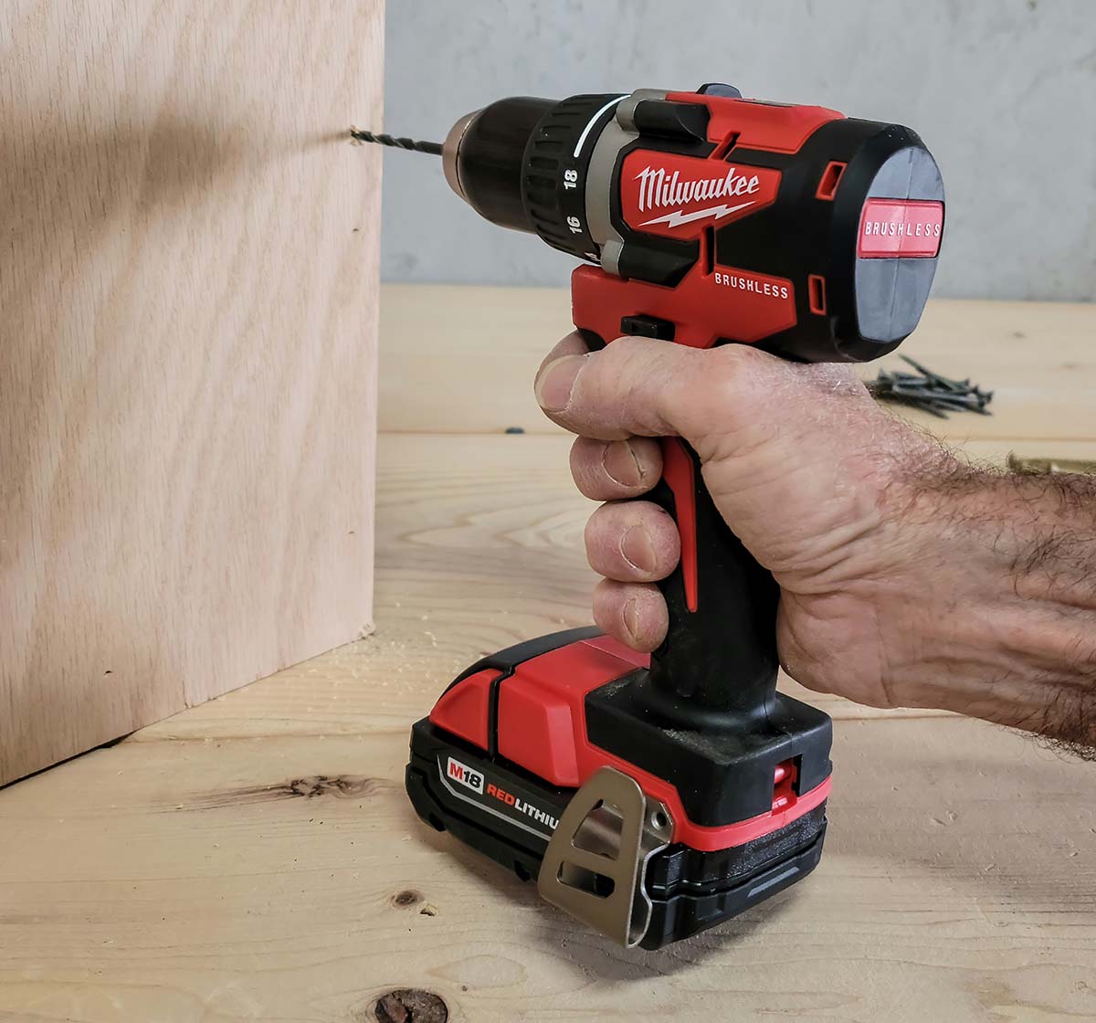 A man uses the best cordless drill to drill a pilot hole in a piece of wood
