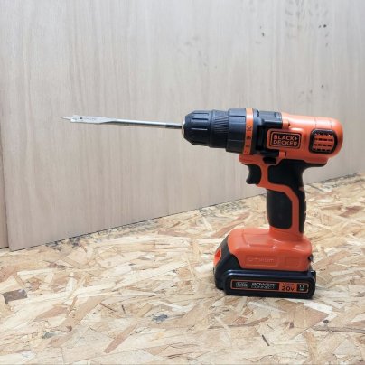 Black+Decker LDX120C 20V MAX Cordless Drill/Driver against a wood wall