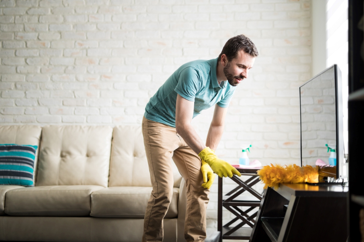Man using duster at home.