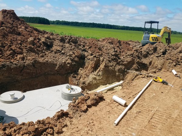 Concrete septic holding tanks being buried for a new home construction.