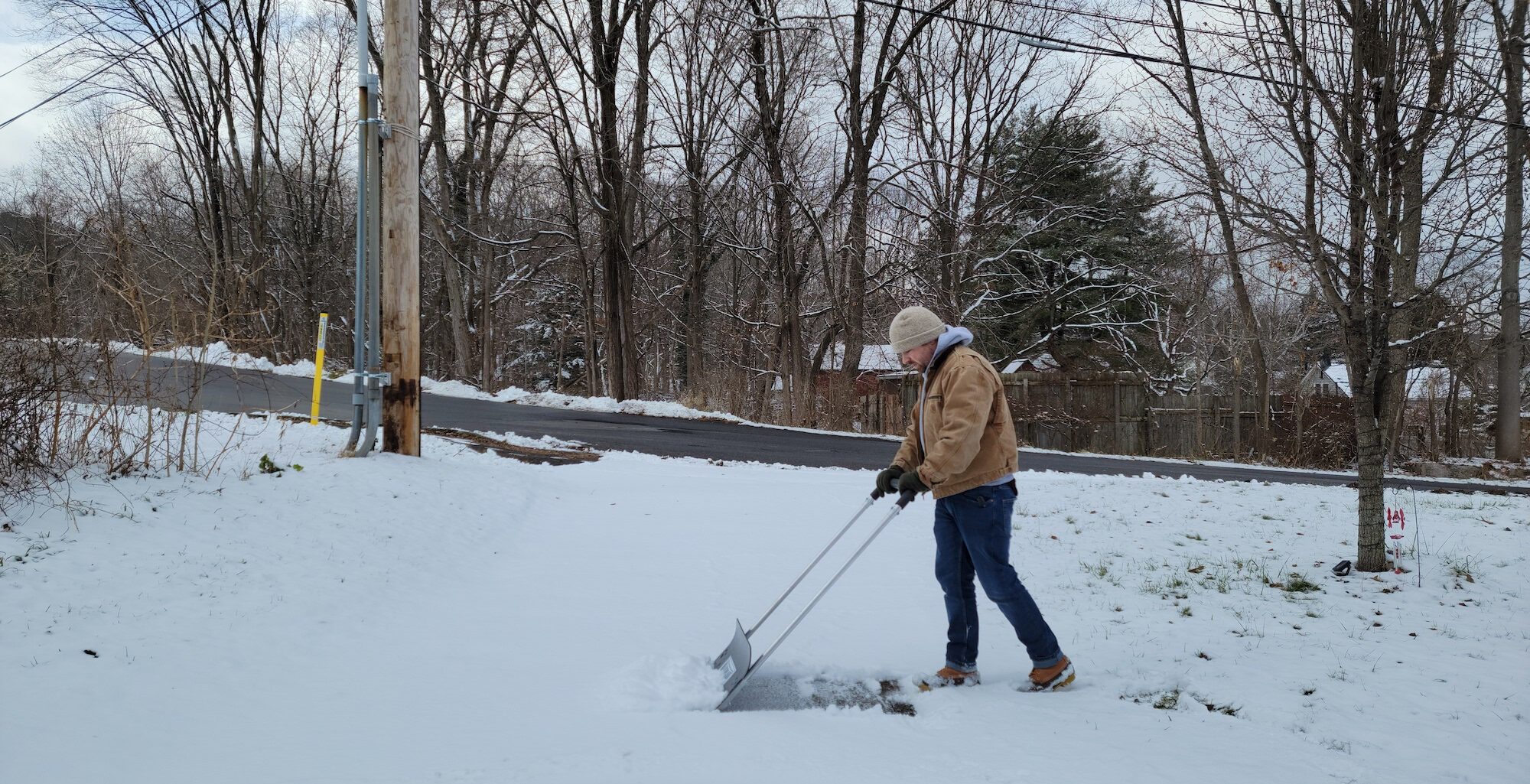 A person using the best snow shovel to clear a path in the snow.