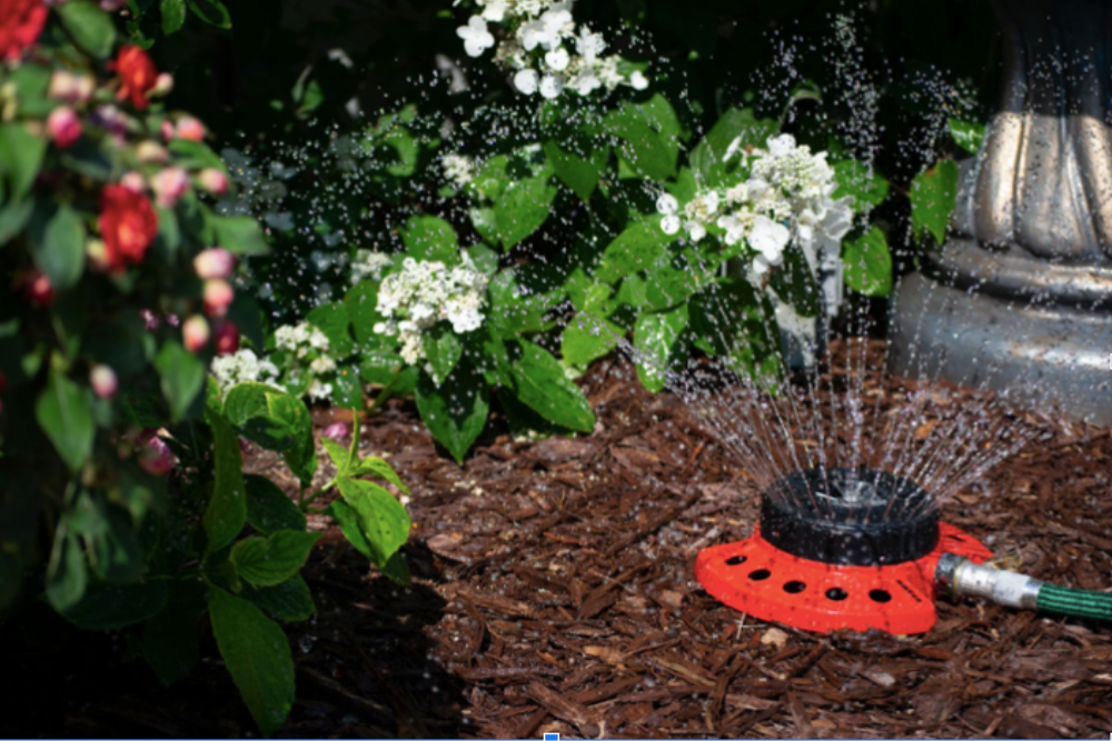 The Dramm 9-Pattern Turret Sprinkler watering a landscaped area during testing.