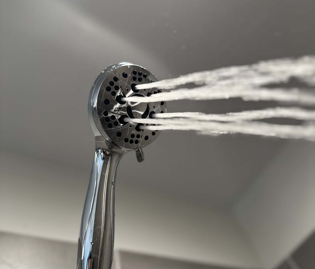 Handheld shower head spraying thick streams of water