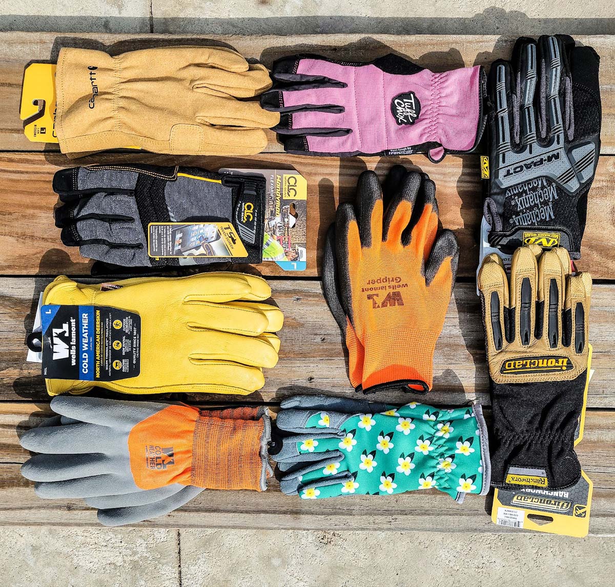 A group of 9 of the best work gloves grouped together on some wooden boards before undergoing testing.