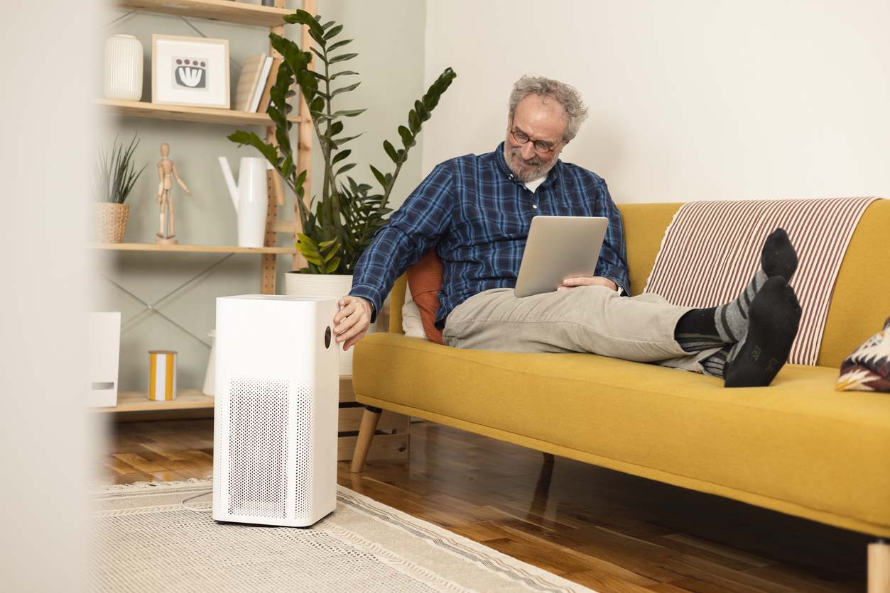 Man turning on his new air purifier using a digital tablet