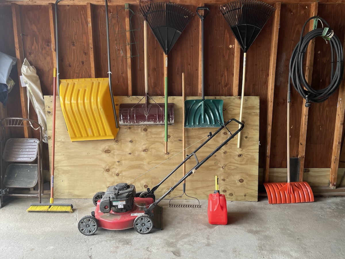 A lawn mower sits in garage storage.
