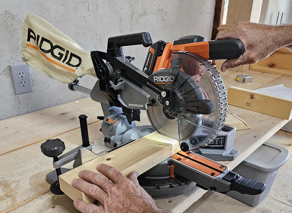 Contractor using Ridgid 7 1/4 inch miter saw to cut a 2 by 4.