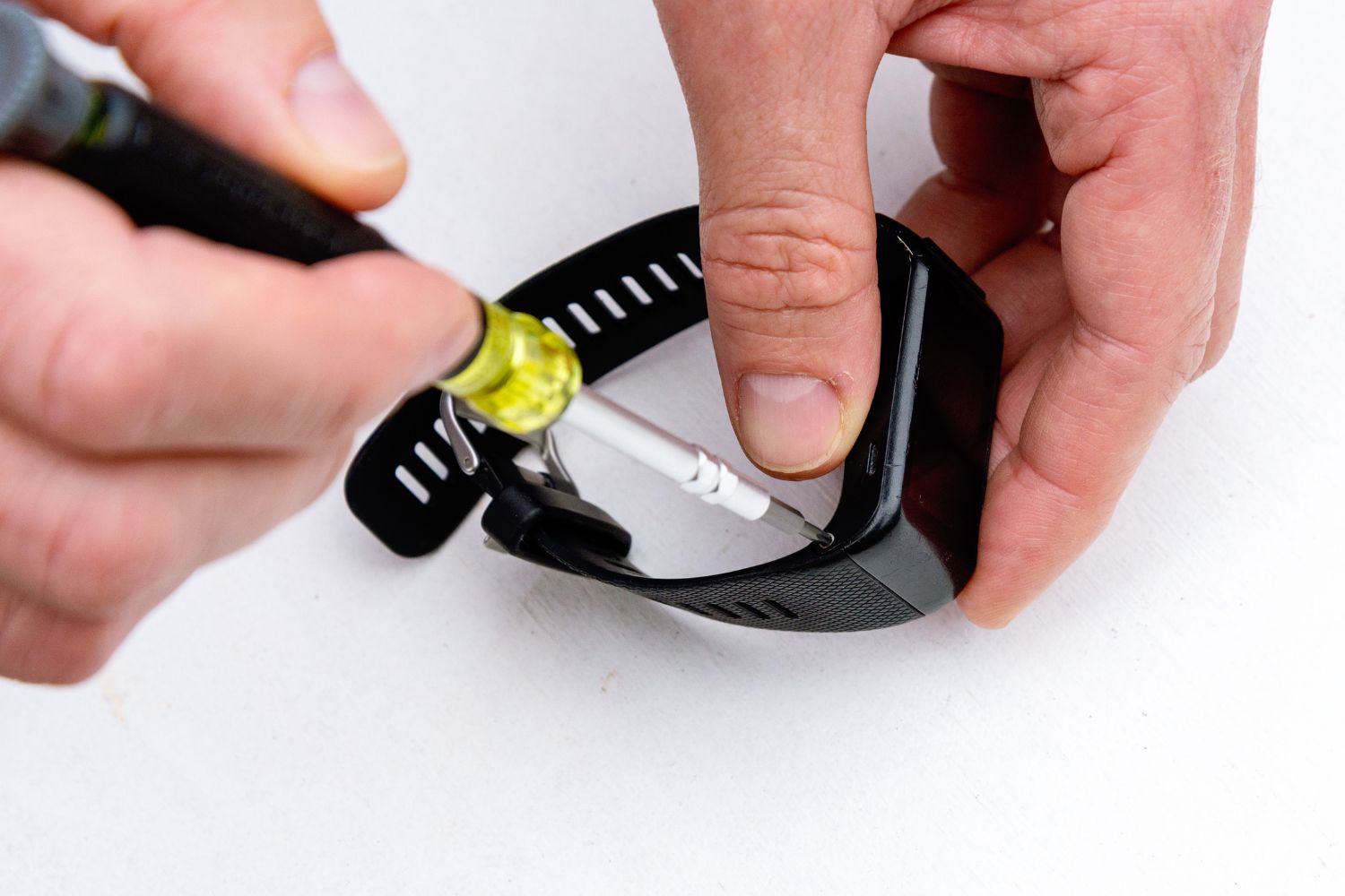 A person using a tool from one of the best screwdriver sets to tighten a watch screw.