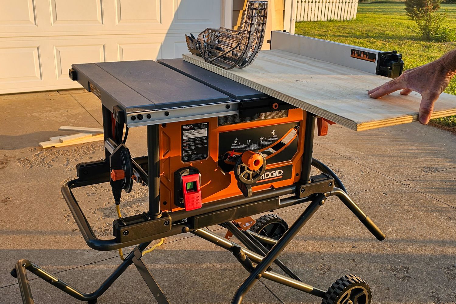 A person using the best table saw option in a driveway