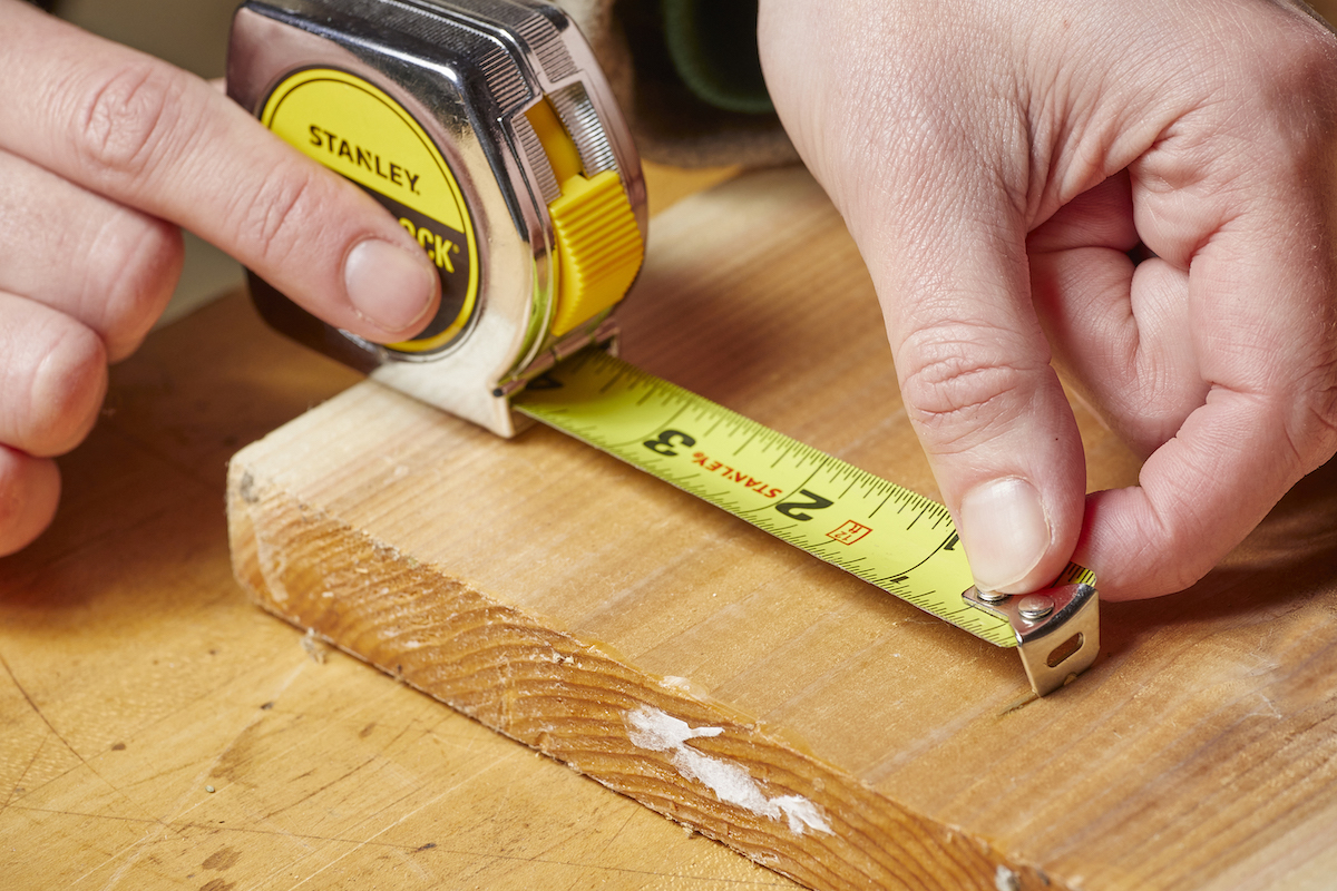 Using the serrated tang on a tape measure to mark a board.