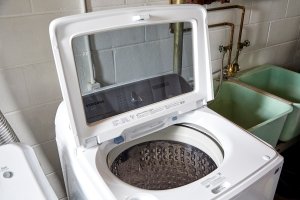 An open washing machine airs out to prevent molding.